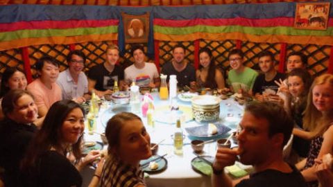 Ben and a large group of students and staff sitting around a table at Mongolian restaurant in Shanghai 