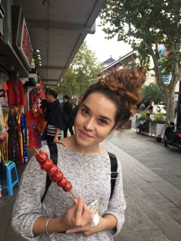 Tereza holding a tanghulu, Chinese candied Hawthorne berries