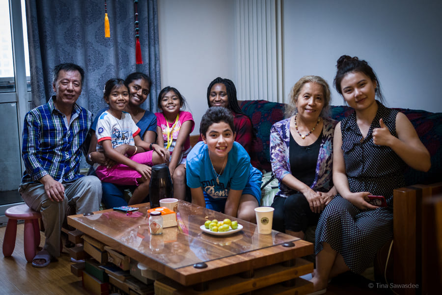 Students and homestay family sitting around a table in the living room